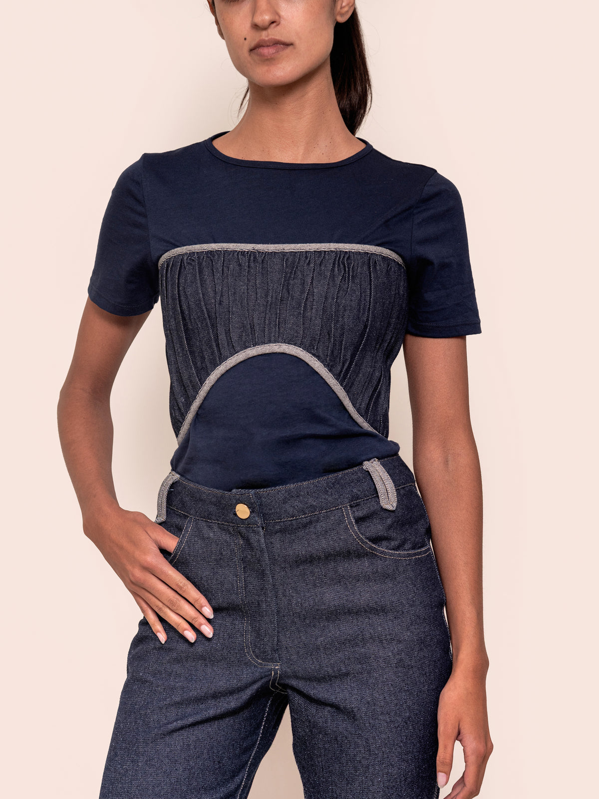 Dark blue short-sleeve crewneck top with textured center panel and white arched trim