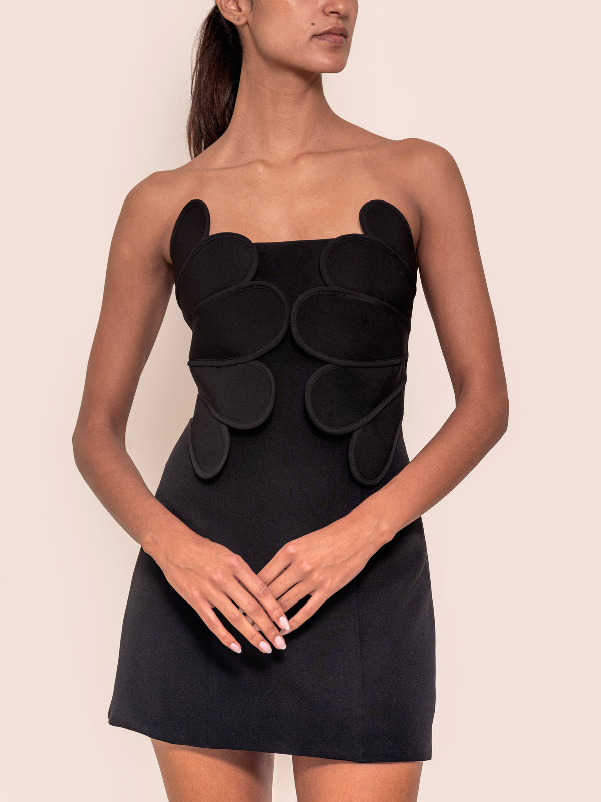Black mini dress with bold circular appliques at the square neckline