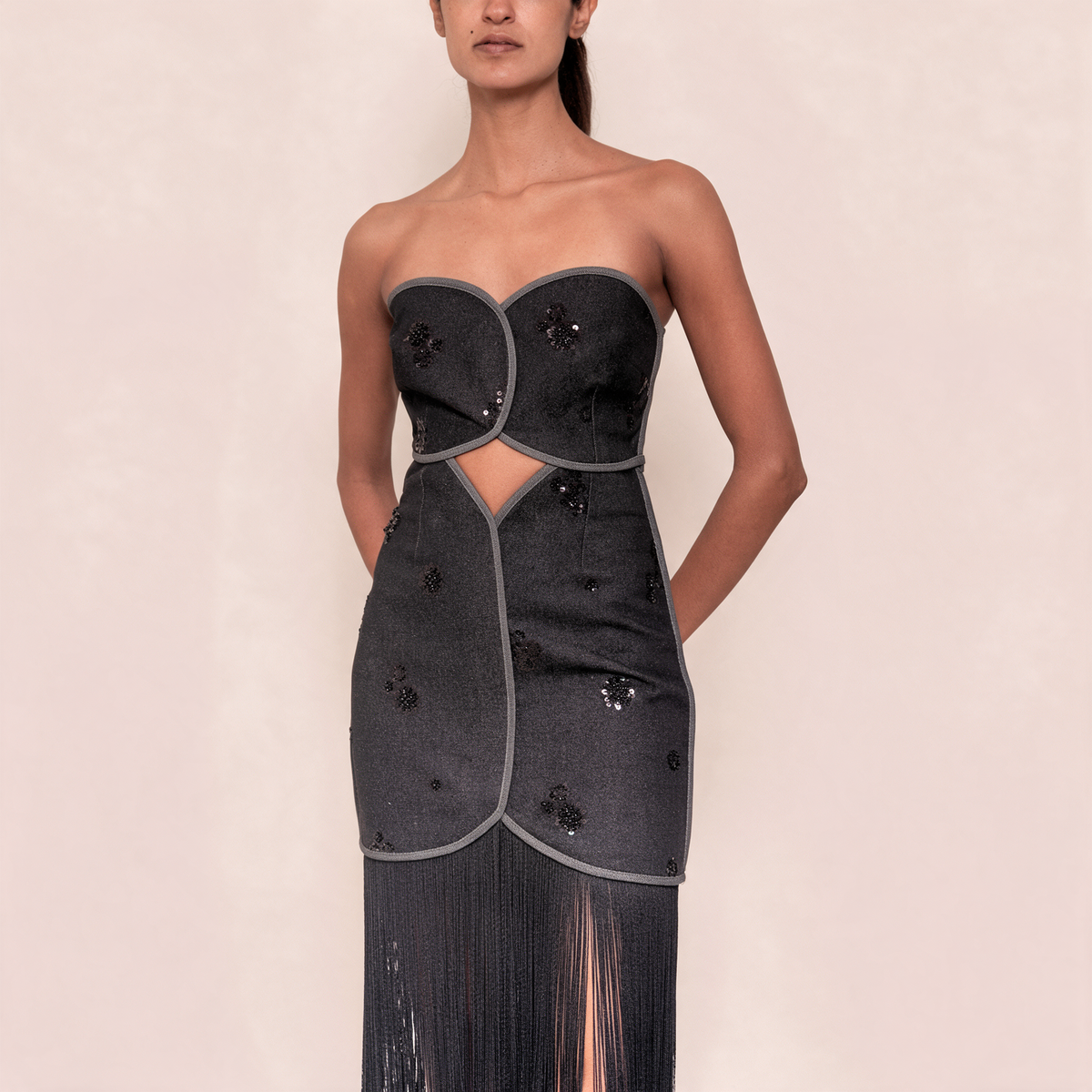 Close-up strapless black denim-look dress with circular bust appliques and beaded details